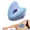 A blue memory foam heart leg pillow is shown resting on a person's leg for side sleeping or pregnancy support.