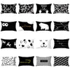 A collection of black and white decorative pillow covers featuring various patterns including floral designs, text, and anima