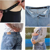 Close-up of an invisible self-adjusting belt tightener being used on a black top and denim jeans.