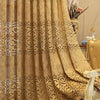 A luxurious golden beige hollow perforated curtain draped elegantly in a room setting.