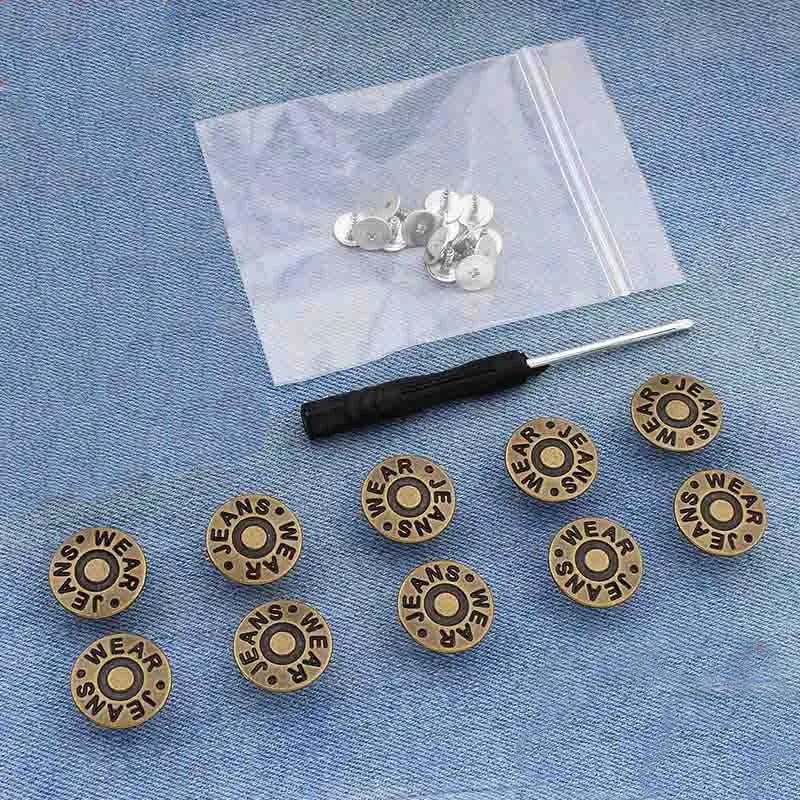 A collection of silver metal button pins is displayed on a translucent white bag against a blue denim background.