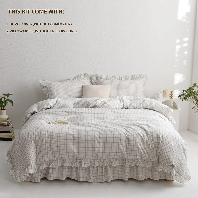 A plaid duvet cover set with a white quilted duvet and two pillowcases displayed on a bed.
