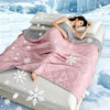 A pink quilted cooling summer blanket with white snowflake patterns is displayed on a bed in a snowy, icy environment.