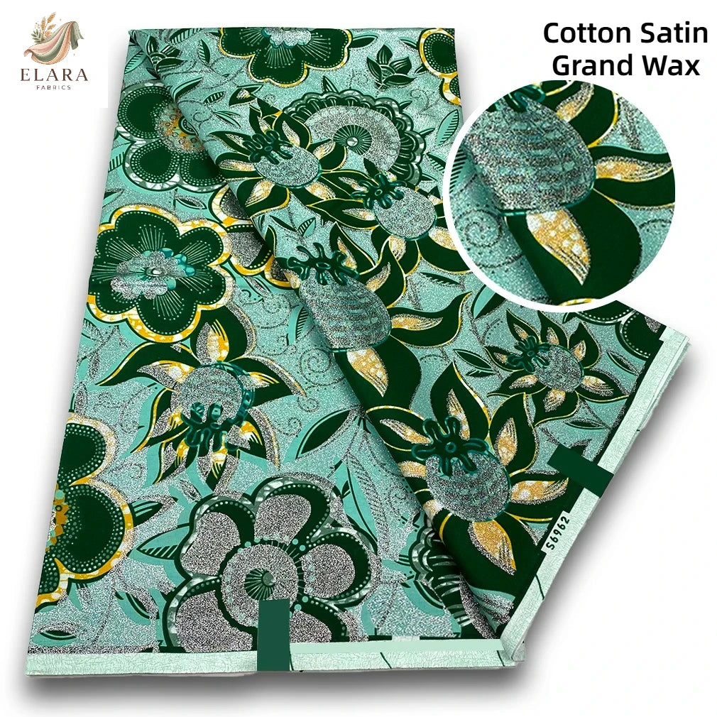 A bolt of Cotton Satin Grand Wax fabric featuring a green and teal floral pattern.