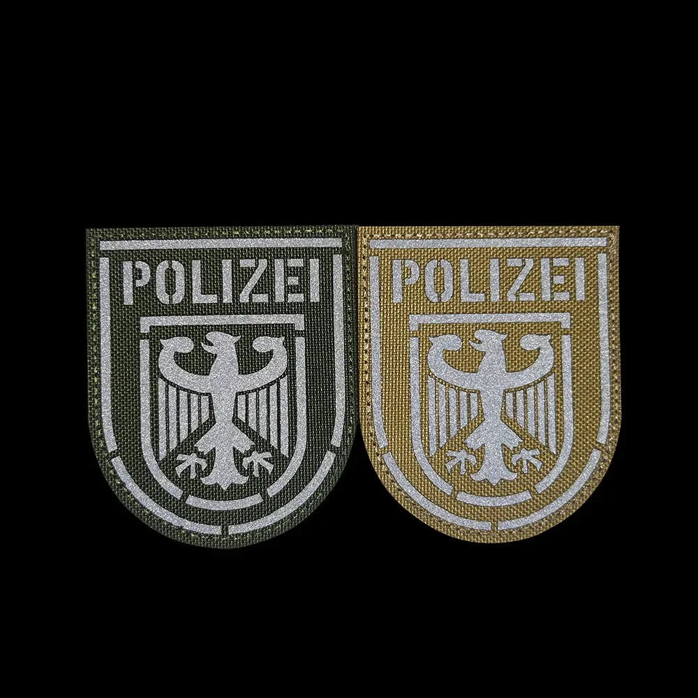 Two embroidered patches featuring an eagle shield design on a dark background.