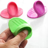 Three silicone oven mitts in pink and green colors are shown, with one being held by a hand.
