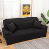 A black elegant faux silk sofa cover displayed on a wooden floor with a patterned rug.