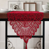 A vibrant red retro lace table runner with tassels displayed on a dark wooden table.