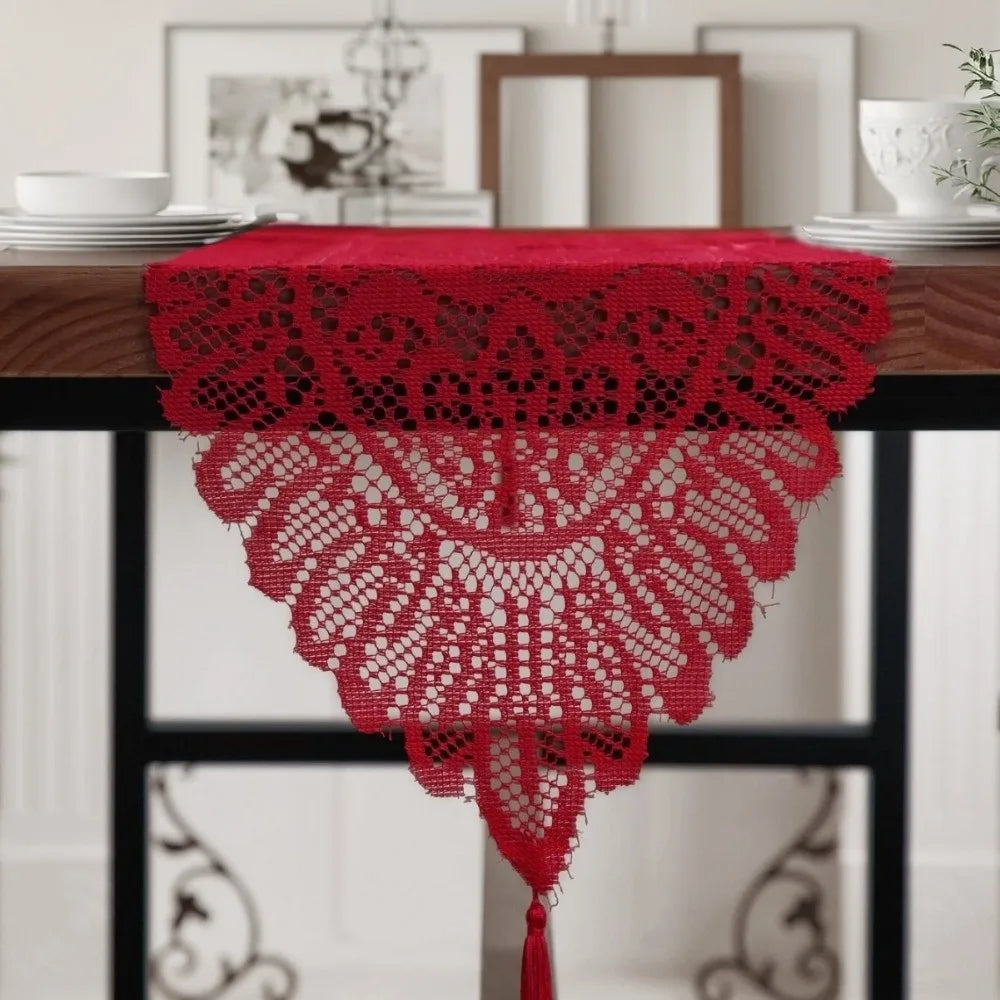 A vibrant red retro lace table runner with tassels displayed on a dark wooden table.