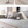 A light gray linen sofa cover with beige accents and a white cup on a modern sofa.