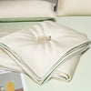 White ice silk cooling quilt folded on a light green surface.
