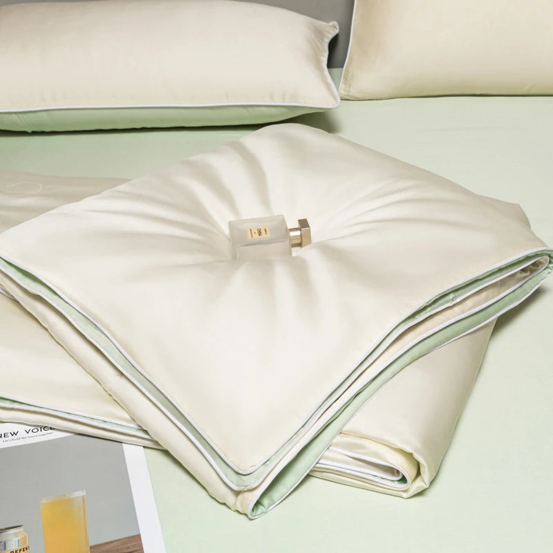 White ice silk cooling quilt folded on a light green surface.