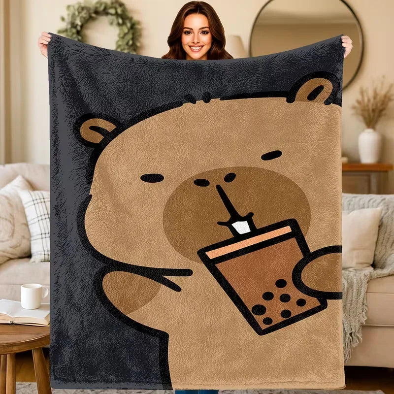 A plush flannel blanket featuring a cartoon bear drinking from a coffee cup.