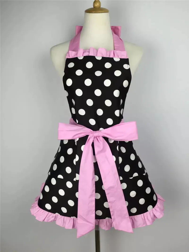 A pink and black polka dot ruffle apron with pockets displayed on a mannequin.