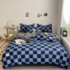 A navy blue and white checkered duvet cover set displayed on a bed with framed pictures on the wall.