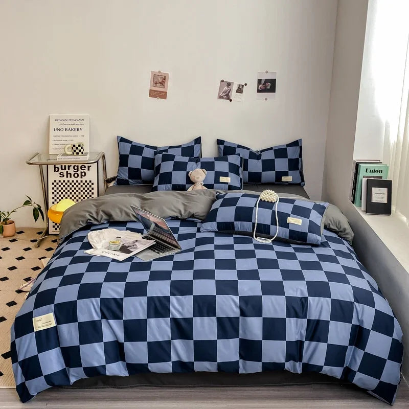 A navy blue and white checkered duvet cover set displayed on a bed with framed pictures on the wall.