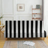 A black and white striped velvet sofa cover displayed on a wooden floor with a rug.