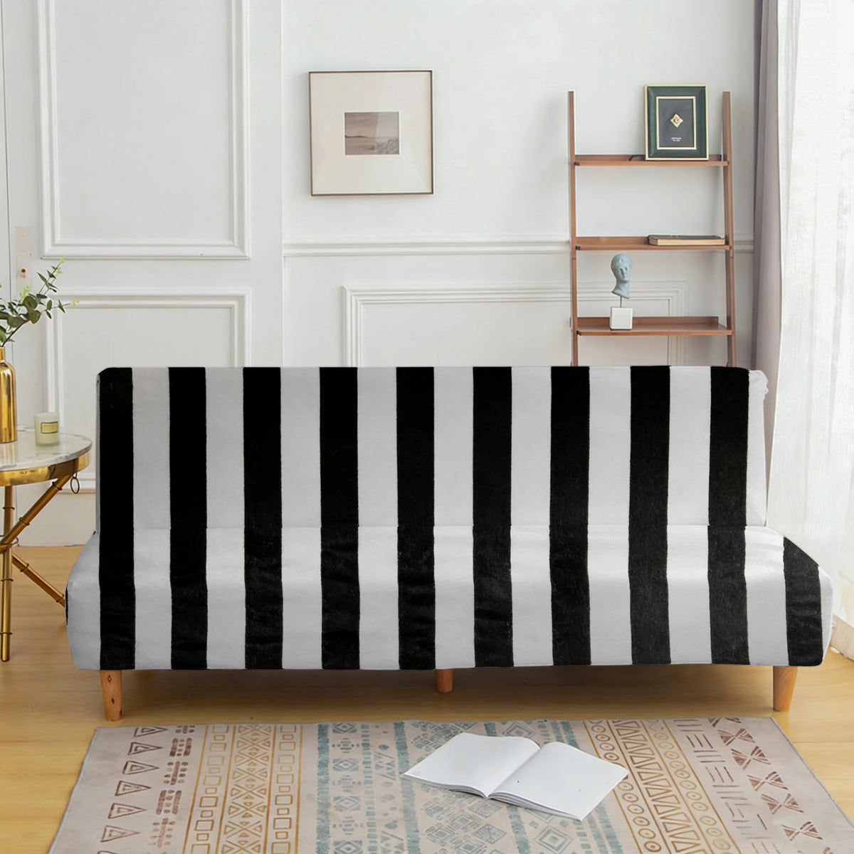 A black and white striped velvet sofa cover displayed on a wooden floor with a rug.