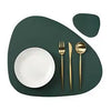A set of gold-colored reusable vinyl placemats featuring a white plate and silverware on a dark green placemat.