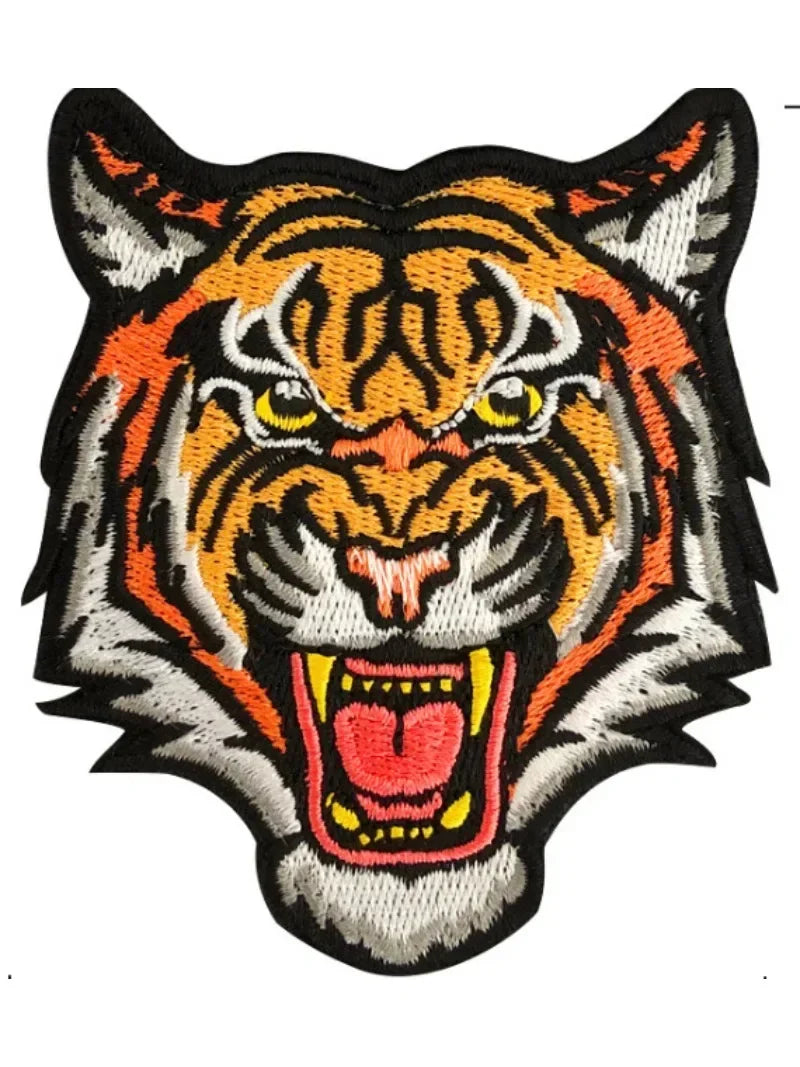 An embroidered patch featuring a fierce orange and black tiger head with yellow eyes and an open mouth.