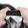 Hands holding a black waterproof BBQ grill cover open to reveal a shiny silver lining.