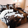 A brown and black cow print yak leather duvet cover set displayed on a bed.