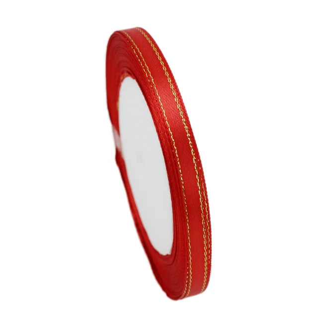 A roll of red satin ribbon with gold edges for gift wrapping and crafts.