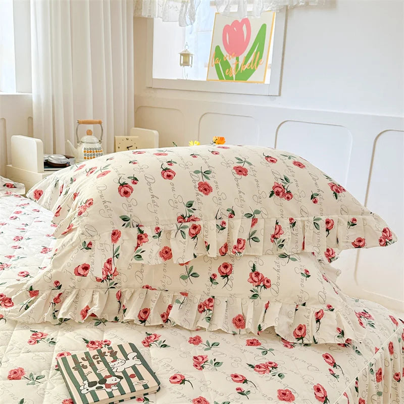Two floral cotton pillow covers featuring pink roses and green leaves on a white background.