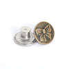 A round brass button with a bow design and a silver button shank.