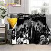 A black and white graphic print featuring a group of men in vintage style on a throw blanket.