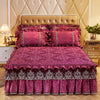 A luxurious magenta bed skirt set featuring ruffled fabric and lace trim on a bed with a tufted headboard.