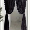 A dark floral lace sheer rod pocket curtain panel hanging in a doorway.
