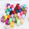 A collection of colorful satin ribbon rolls in various shades arranged in a row for crafts and gift wrapping.