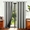 Gray thermal insulated blackout curtains hanging in a doorway with a green garden view