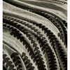 Close-up of a gray and black herringbone chenille sofa cover with decorative tassel fringes.