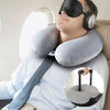A person is using a light blue shirt and a gray U-shaped neck pillow for support.