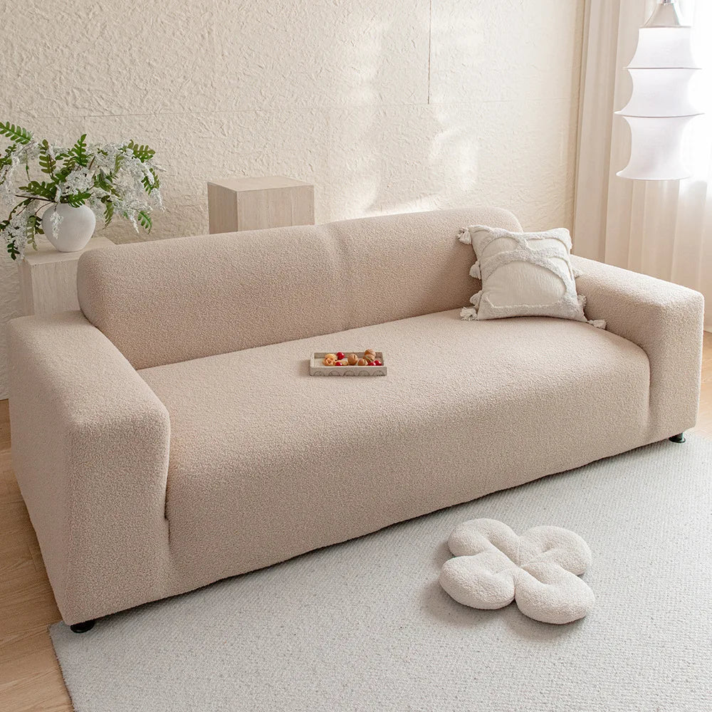 A beige jacquard velvet sofa cover displayed on a light-colored rug in a bright room.