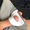 A hand holds a white sewing guide tool with 3mm spacing against a gray fabric.