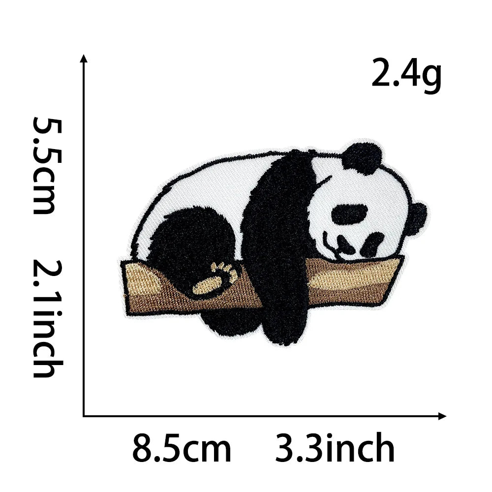 A black and white panda embroidery patch measuring 2.4g, shown resting on a tan fabric background.