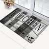 A rectangular black and white striped kitchen mat with the text SEASONED WITH LOVE