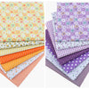 A collection of colorful floral dot pattern cotton fabric squares in various shades of yellow, orange, purple, and green.