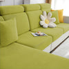 A lime green polar fleece sofa seat cushion cover with a floral accent pillow on a light-colored sofa.