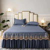 A navy blue embroidered cotton bedspread and pillow set displayed on a bed with gold accents.