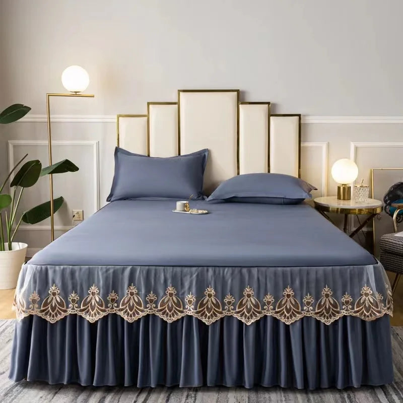 A navy blue embroidered cotton bedspread and pillow set displayed on a bed with gold accents.
