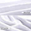 Close-up of a white plush fleece blanket showing soft texture and folds.
