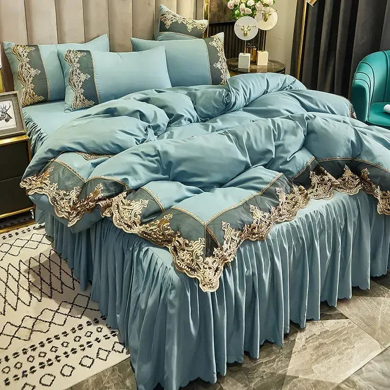 A teal bed skirt set featuring lace edge detailing and gold embroidery on a bed with light blue pillows.