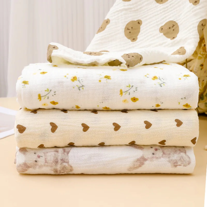 Stack of white printable cotton crib sheets with yellow floral patterns and a brown animal print sheet.