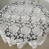 White floral lace tablecloth with scalloped edges displayed on a round table.