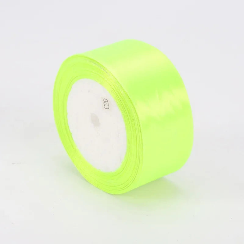 A roll of neon yellow satin ribbon for crafts and gift wrapping.