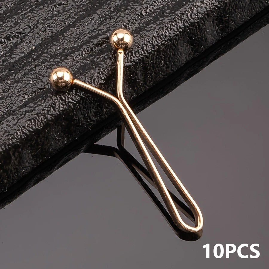 A set of ten gold-toned metal lapel clips with spherical heads shown against a dark background.
